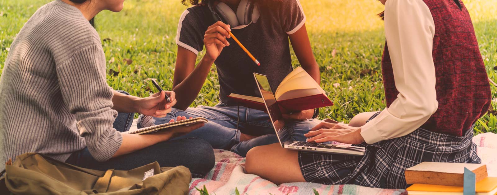 Teenage students working together in a park.